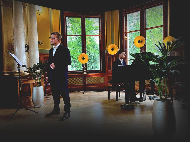 Adam Głowacki śpiewający z akompaniamentem fortepianu